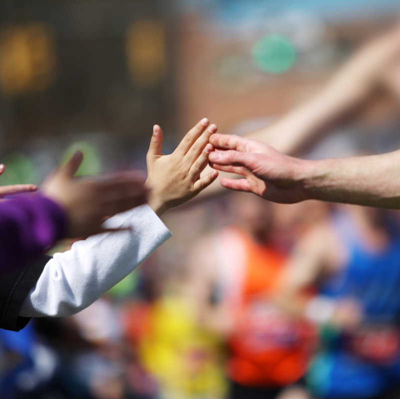 Kids give a high five to runners.